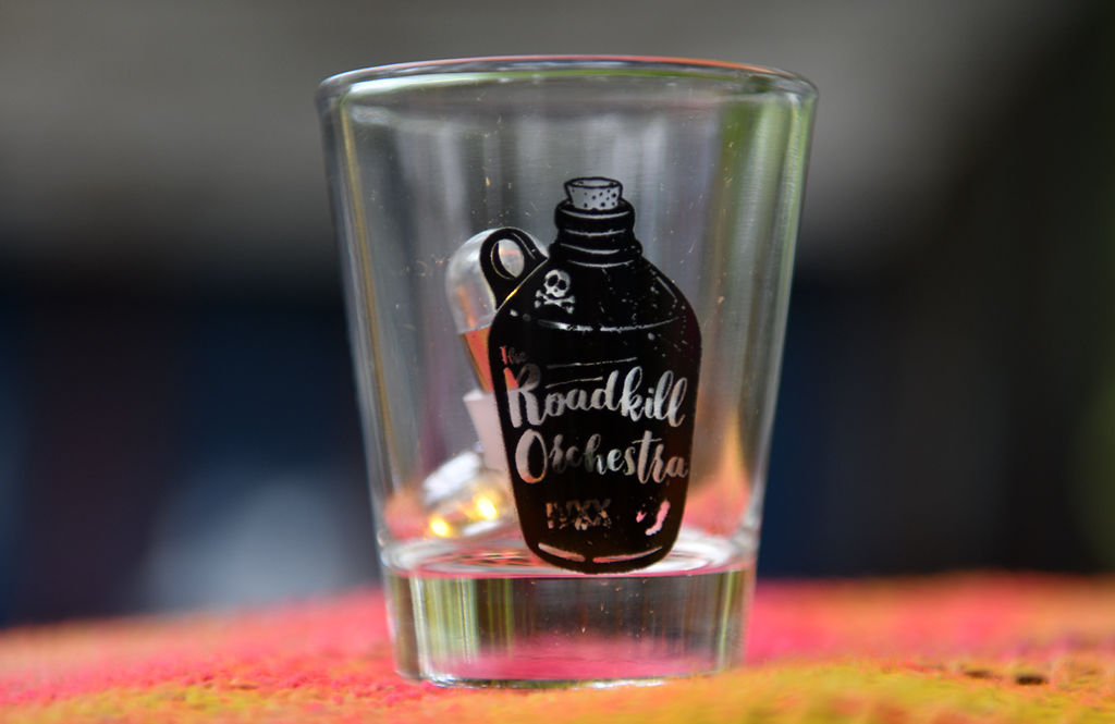 A shot glass with The Roadkill Orchestra's logo is used as a piece of outdoor decoration